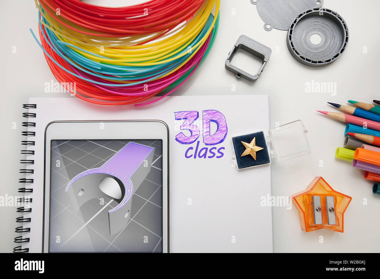 Un assortiment de fournitures utilisées dans une classe d'impression 3D qui comprend une tablette, exemples imprimés et modèle 3d pour l'impression 3d à l'écran. Banque D'Images
