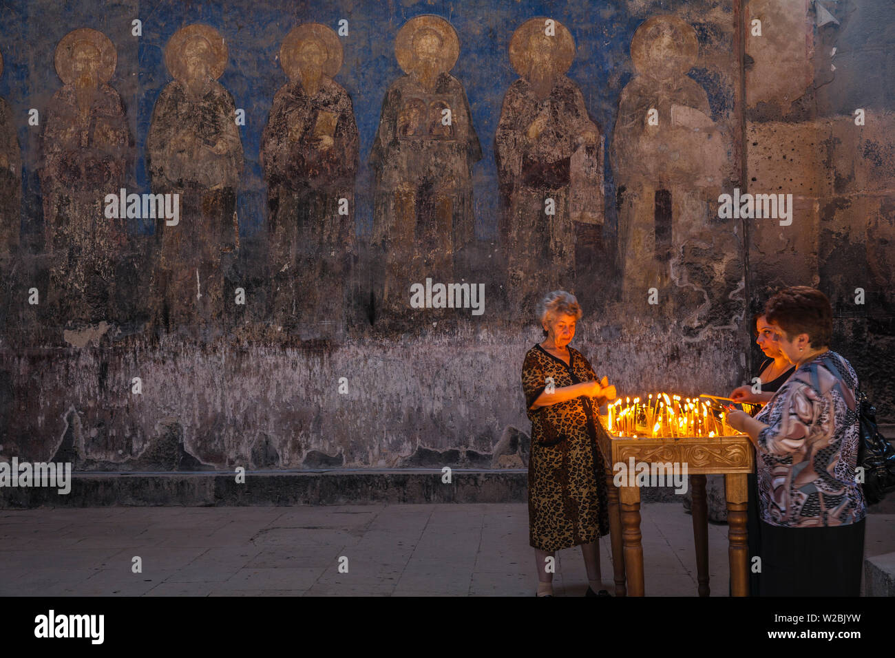 L'Arménie, Lori Province, Akhtala, allumant des bougies Femmes au monastère Akhtala Banque D'Images