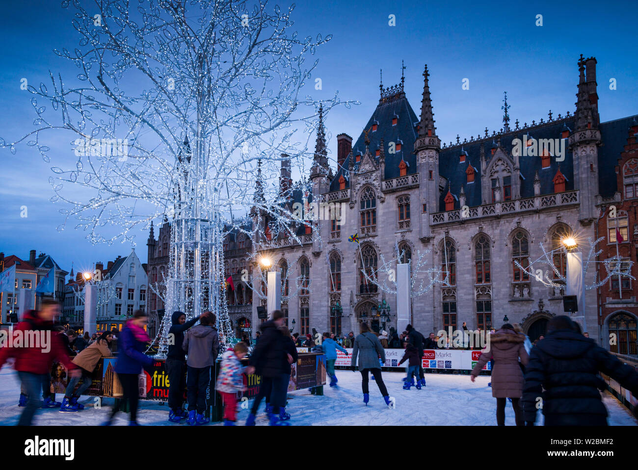Belgique, Bruges, le Markt, Provinciaal Hof ancien bâtiment gouvernemental et patinoire, dusk Banque D'Images