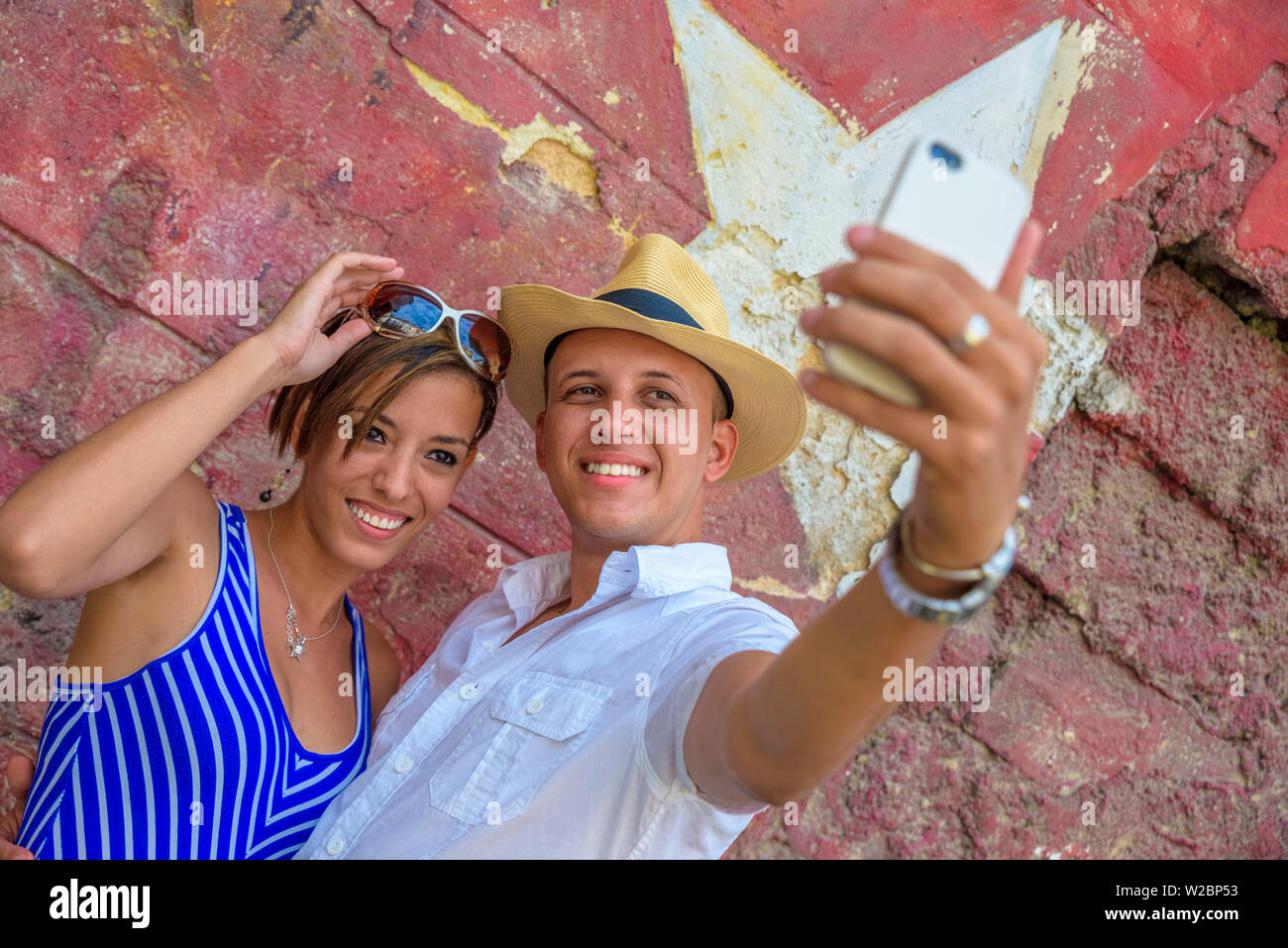 Cuba, La Havane, un couple de touristes en face de peinture murale selfies Banque D'Images