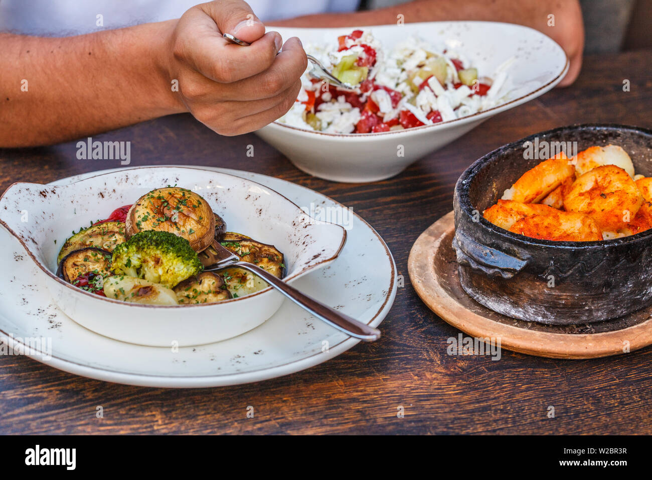 Alimentaire nationale monténégrine. Crêpes salées avec de la viande et le fromage dans un pot en fer, des légumes et de la salade sur la table dans le restaurant. Banque D'Images