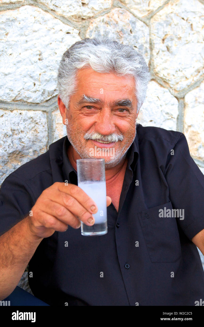 Smiling homme grec Ouzo Potable, Kalymnos, Dodecanese, îles grecques, Grèce, Europe Banque D'Images