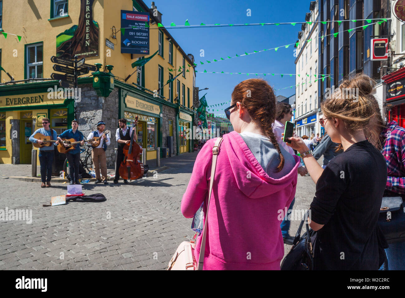 L'Irlande, dans le comté de Galway, Galway City, High Street, les musiciens et le public Banque D'Images