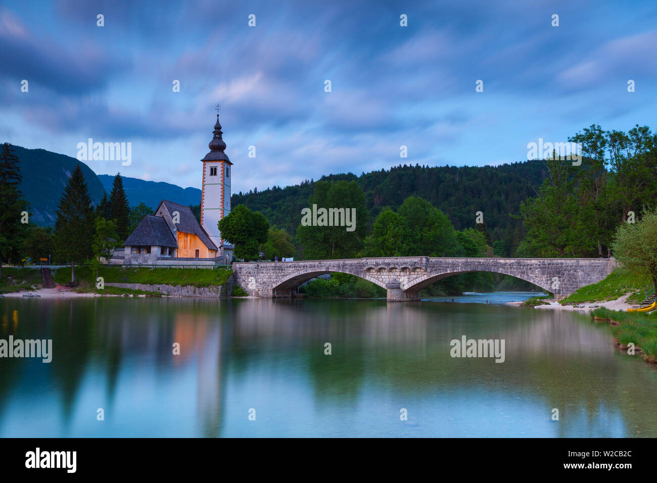 Lac de Bohinj & l'église Saint Jean Baptiste allumé à la tombée du jour, le parc national du Triglav, en Slovénie Banque D'Images