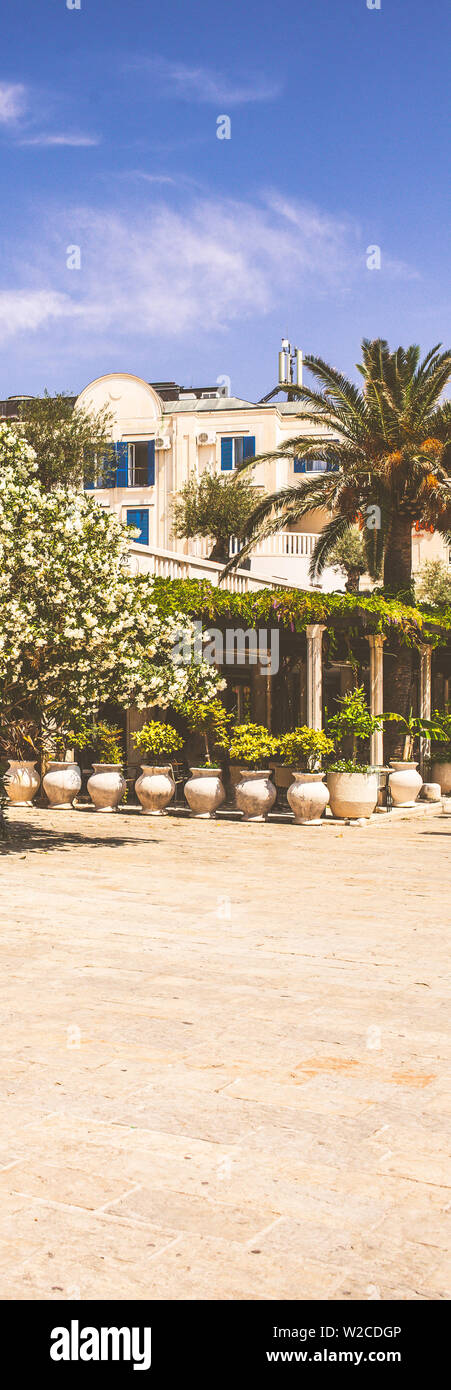 Terrasse d'un restaurant à l'arrière-plan d'un hôtel blanc au Monténégro. Banque D'Images