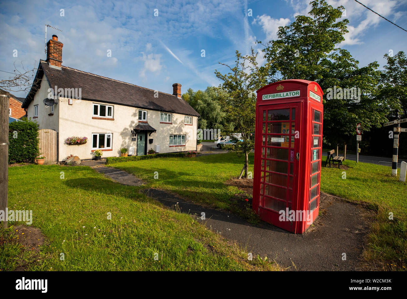 Un ancien téléphone rouge fort qui a été converti en un défibrillateur dans le village de Twemlow Green, Cheshire. Avec le besoin de téléphones publics en baisse, les organismes de bienfaisance de tout le Royaume-Uni ont trouvé une nouvelle utilisation pour le rouge emblématique des cabines téléphoniques en les utilisant comme des foyers pour l'accès du public aux défibrillateurs. Banque D'Images