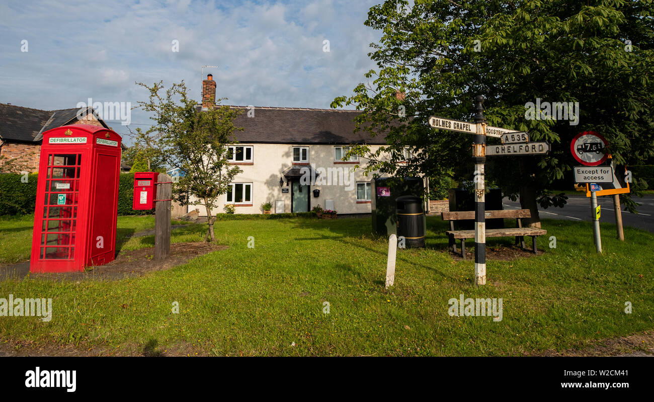 Un ancien téléphone rouge fort qui a été converti en un défibrillateur dans le village de Twemlow Green, Cheshire. Avec le besoin de téléphones publics en baisse, les organismes de bienfaisance de tout le Royaume-Uni ont trouvé une nouvelle utilisation pour le rouge emblématique des cabines téléphoniques en les utilisant comme des foyers pour l'accès du public aux défibrillateurs. Banque D'Images