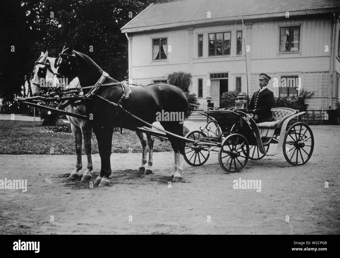 Cheval et chariot. Un homme en uniforme est assis prêt dans le chariot tiré par deux chevaux. Suède 1910 Banque D'Images