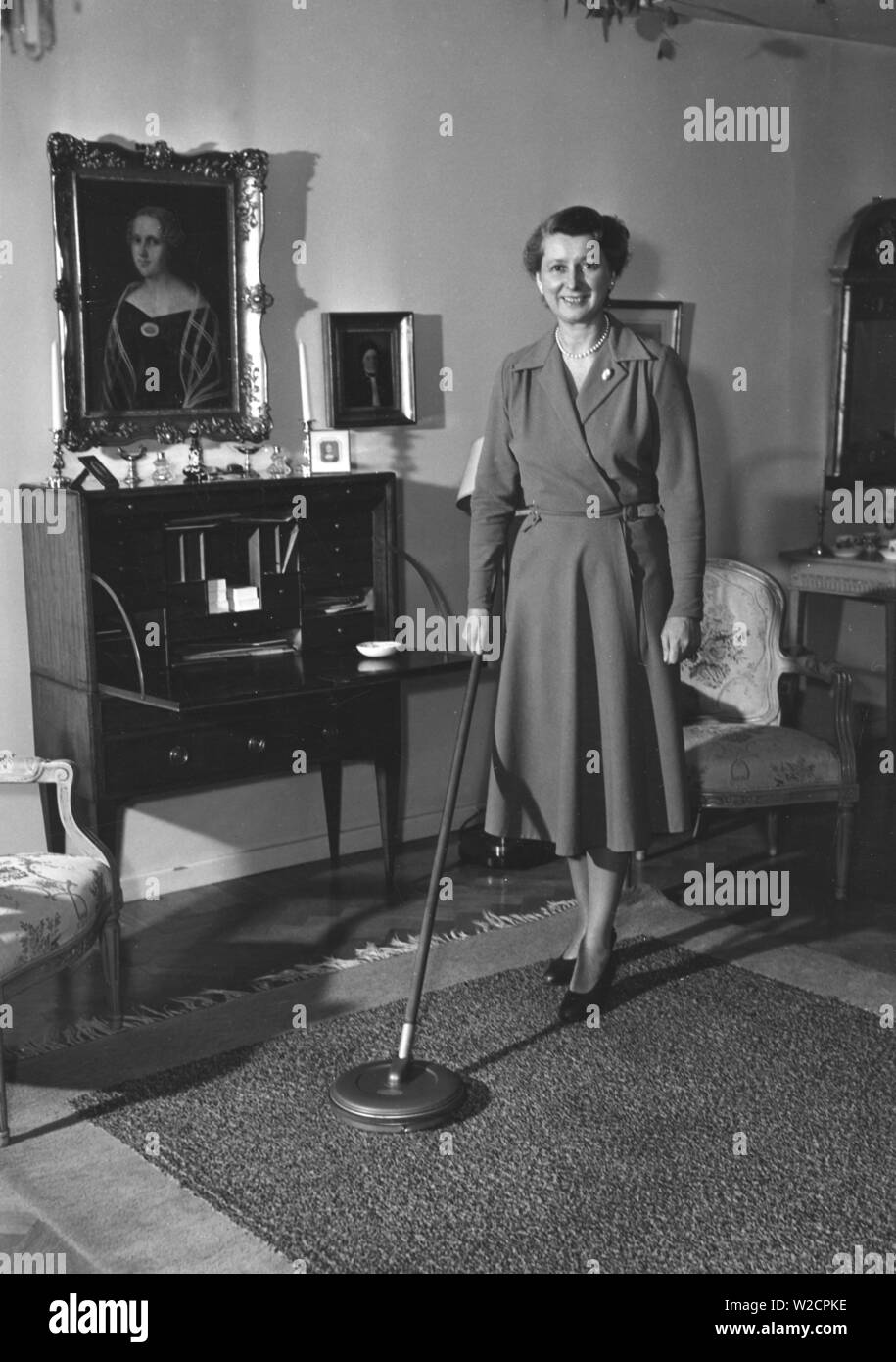 Journée de nettoyage dans les années 1950. Une femme au foyer est la démonstration de la dernière version de l'appareil de nettoyage pour nettoyer les tapis. Suède 1950 Banque D'Images