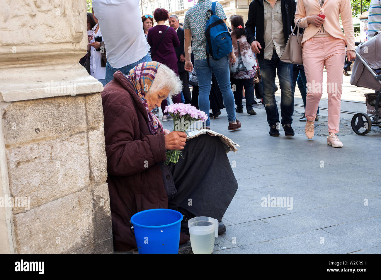 Lviv, Ukraine - 26 mai 2019 : vente de fleurs. Vieille Femme assis sur rue et reading newspaper Banque D'Images