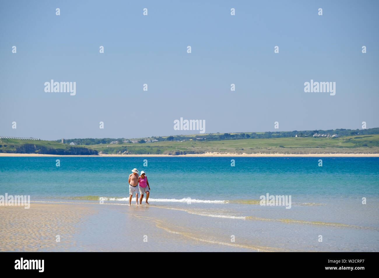 Personnes âgées en train de marcher le long du rivage sur la plage de Cornwall Godrevy Banque D'Images