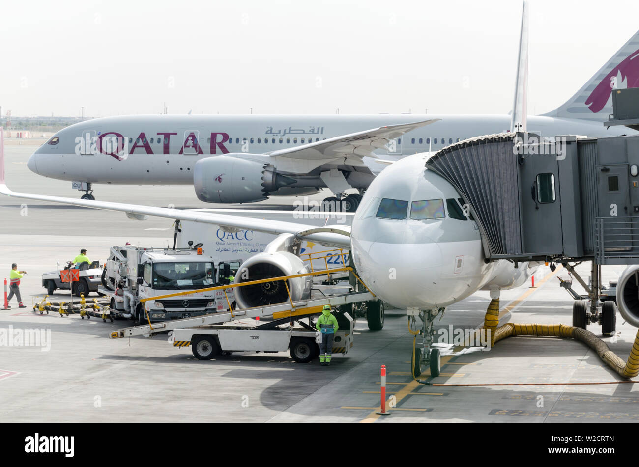 L'Aéroport International Hamad, Doha, Qatar 2018-05-01 : Deux avions de la compagnie aérienne à l'aéroport. Passerelle à l'avion, vue de face. La journée de travail à l'aéroport Banque D'Images