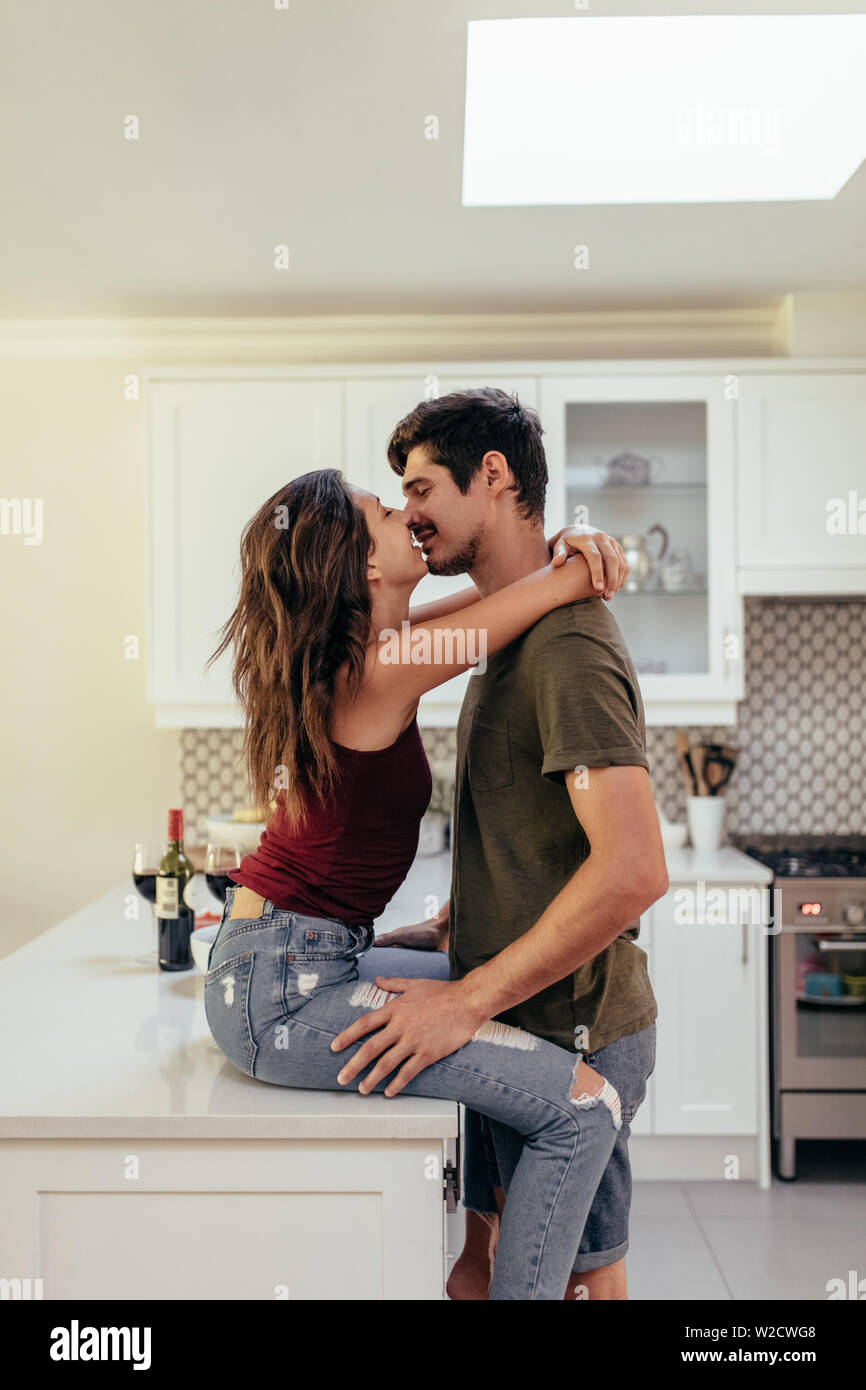 Young couple ensemble dans la cuisine à la maison. Couple in love kissing at home. Banque D'Images