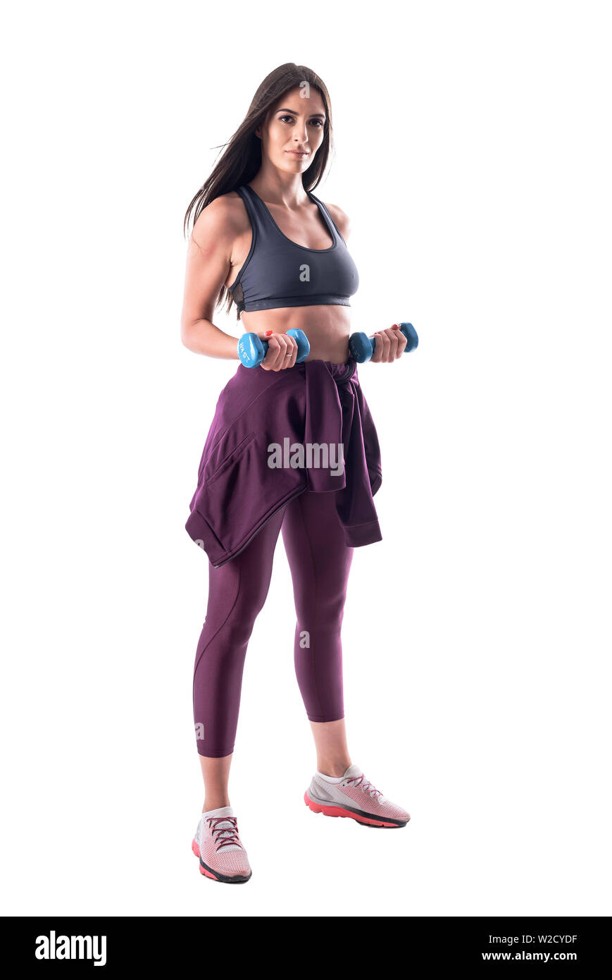 Athletic fit young woman in sportswear biceps bras faisant des exercices avec haltère. Corps plein isolé sur fond blanc. Banque D'Images