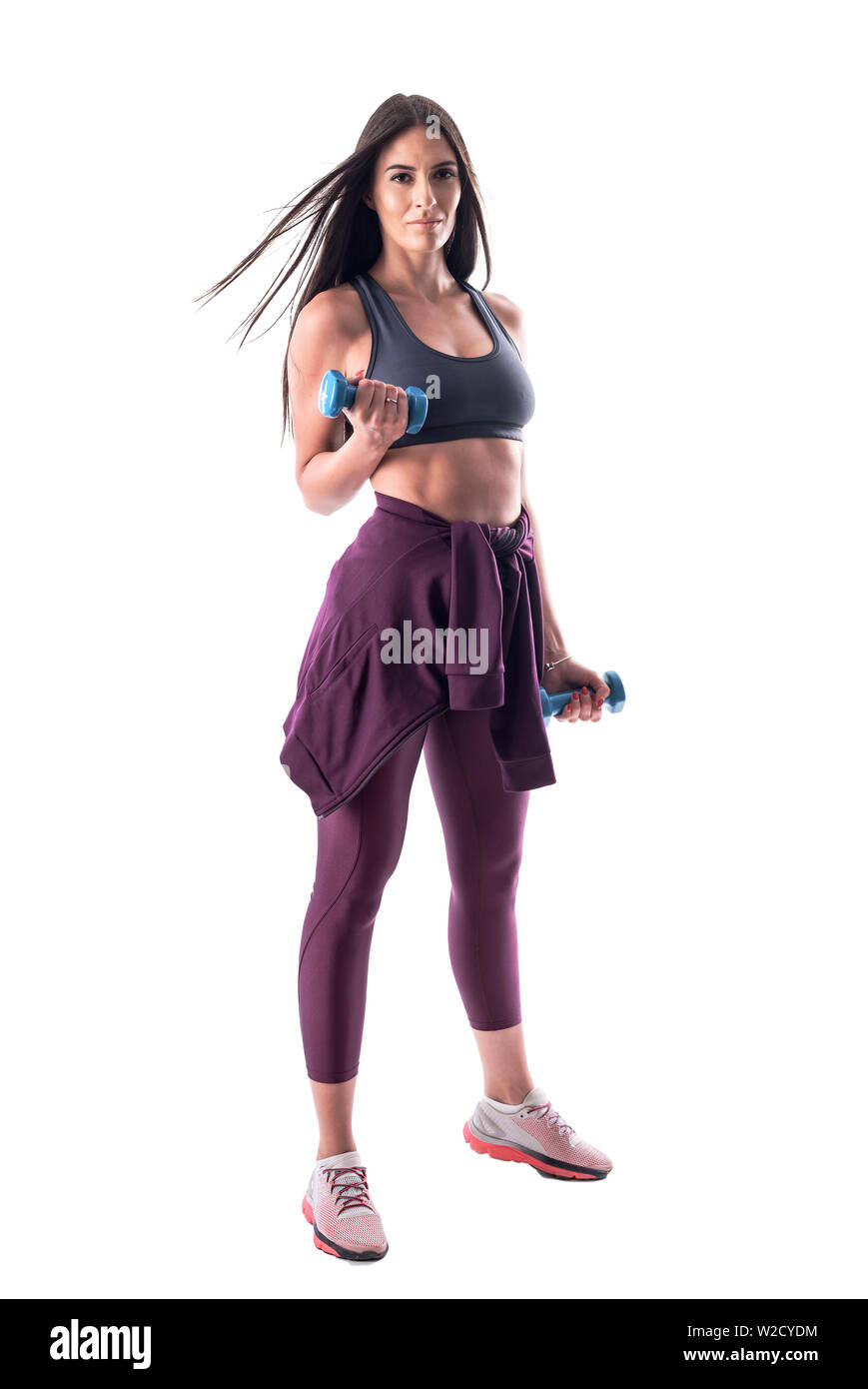 Photo de l'ajustement dynamique athletic jeunes femme latine faisant des exercices avec haltère biceps avec le vol des cheveux. Corps plein isolé sur fond blanc. Banque D'Images