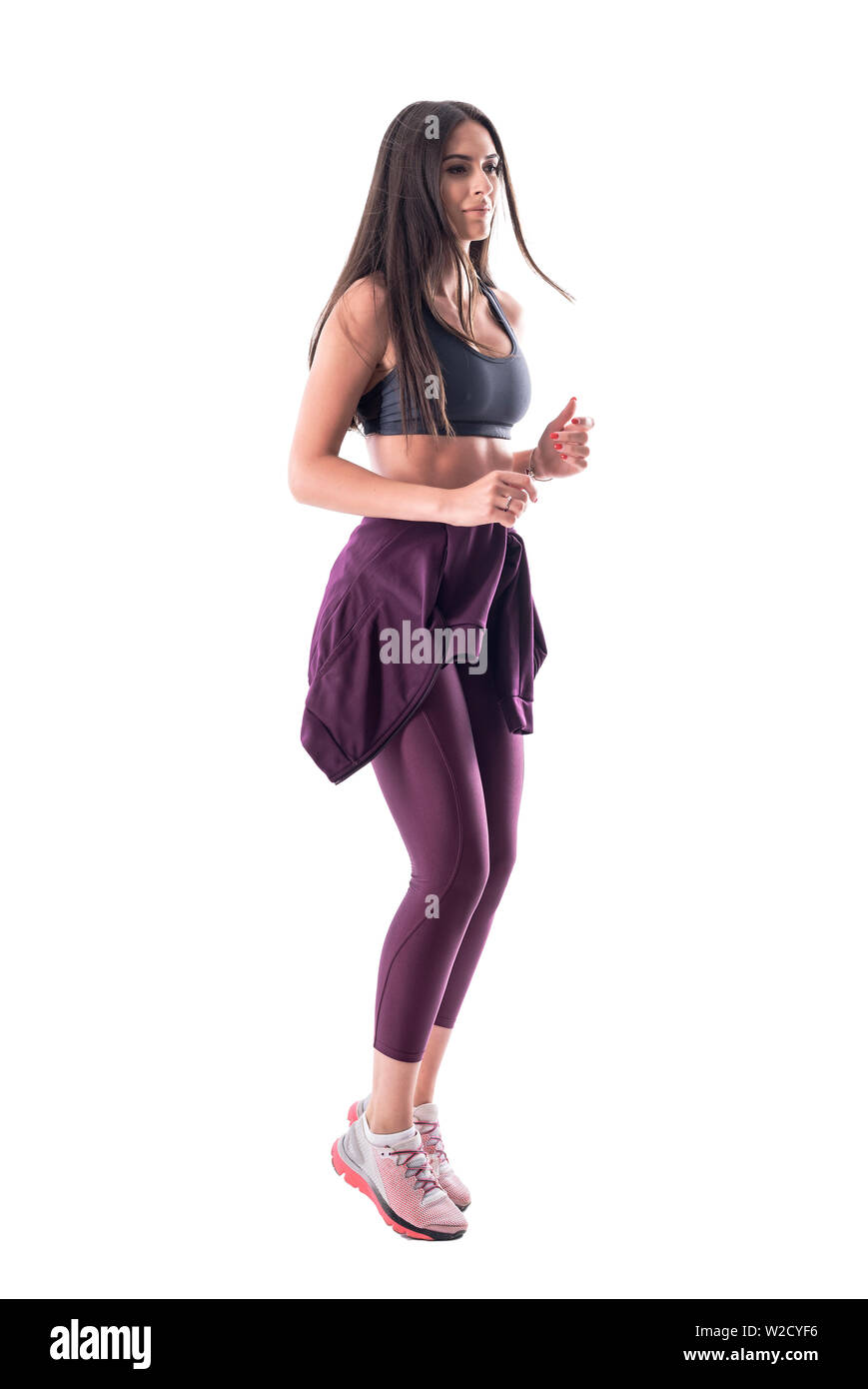 Side view of young fit femme saine en jogging pantalon de yoga et son débardeur. Corps plein isolé sur fond blanc. Banque D'Images