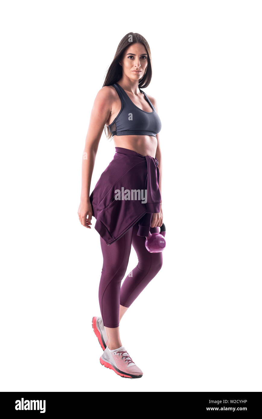 Fit young woman posing with modèle fitness kettlebell looking at camera. Corps plein isolé sur fond blanc. Banque D'Images