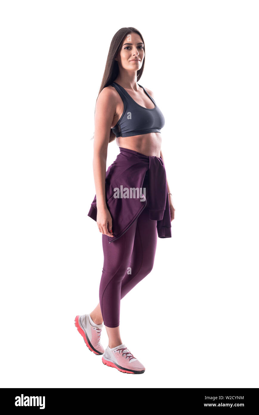 Vue latérale du modèle de remise en forme féminin attrayant avec beaucoup d'abs en tenue de sport. Corps plein isolé sur fond blanc. Banque D'Images