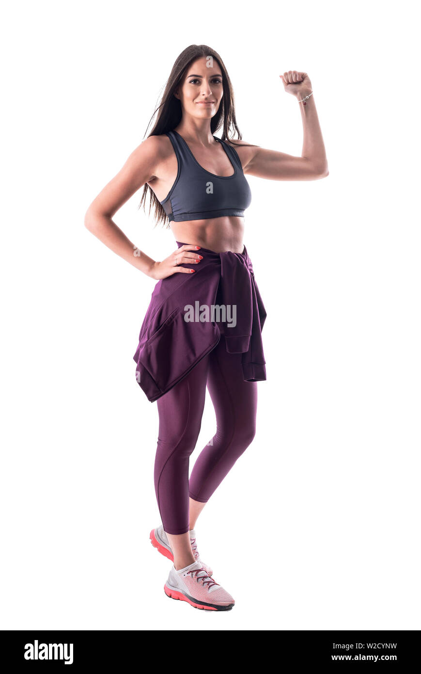 Les jeunes motivés monter attrayant sain woman flexing biceps et montrant du bras. Corps plein isolé sur fond blanc. Banque D'Images