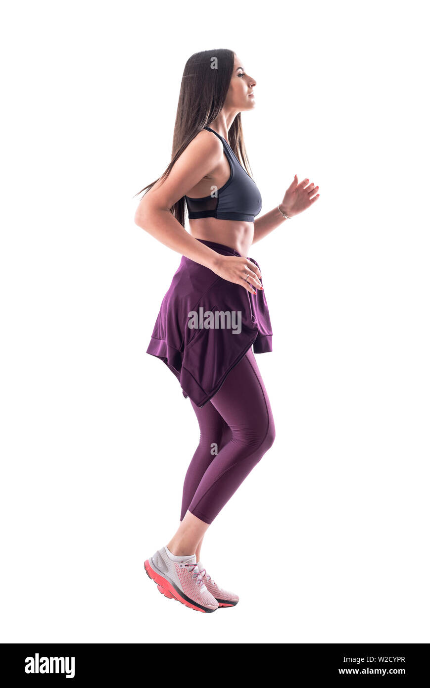 Vue latérale des beaux cheveux longs fit woman jogging en vêtements de sport. Corps plein isolé sur fond blanc. Banque D'Images
