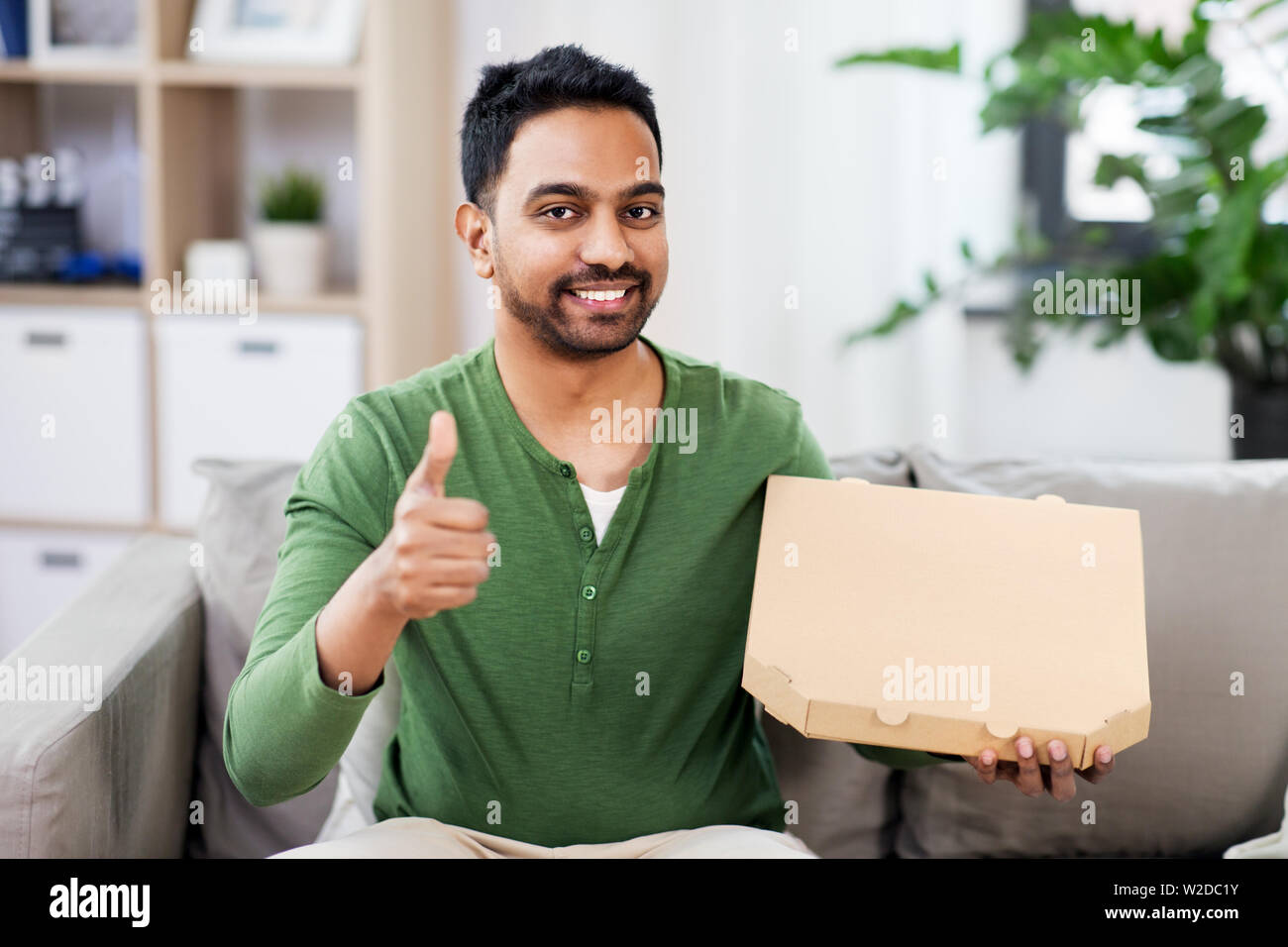 L'homme indien avec pizzas à emporter showing Thumbs up Banque D'Images