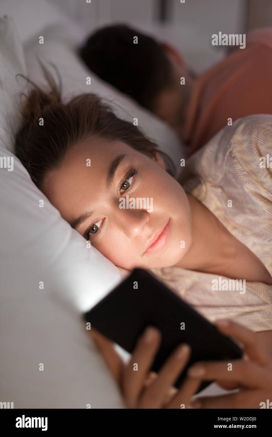 Woman using smartphone alors qu'ami est en train de dormir Banque D'Images