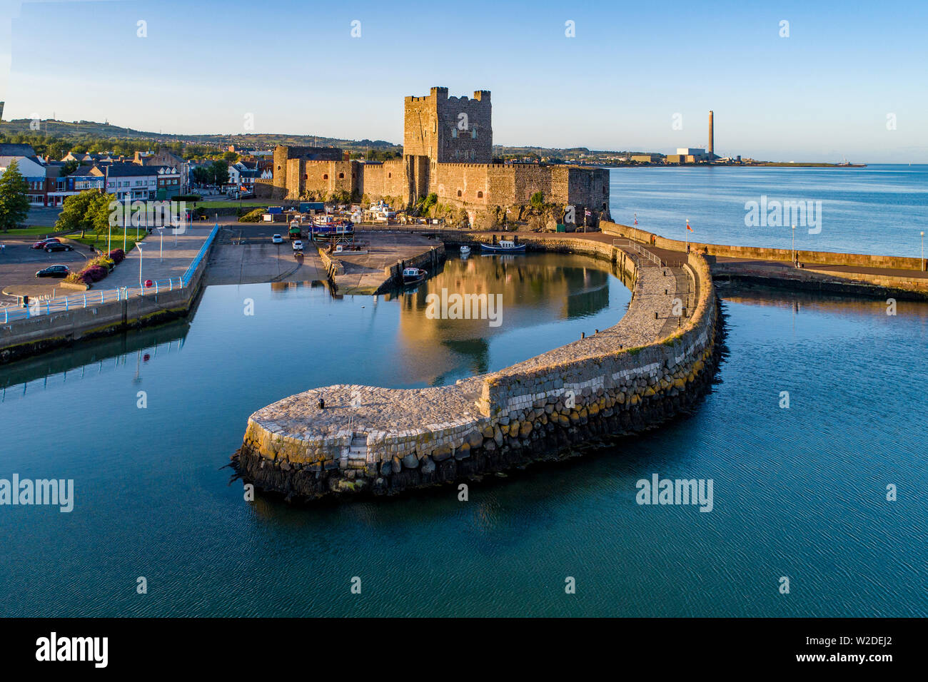 Cité médiévale du château normand et le port à Carrickfergus près de Belfast, en Irlande du Nord, Royaume-Uni. Vue aérienne au coucher du soleil la lumière. Ancienne dans l'arrière-plan Banque D'Images