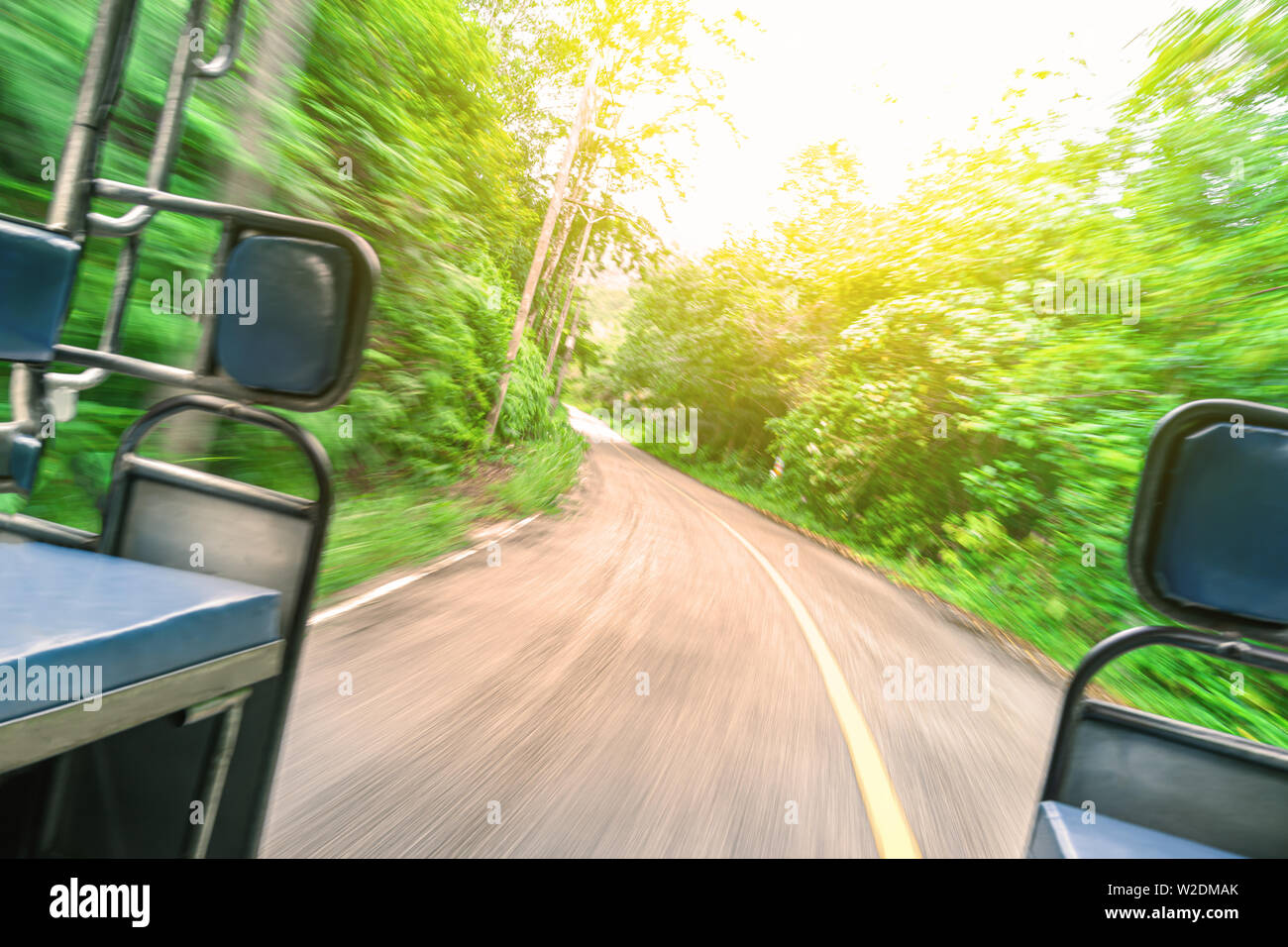 Point de vue tourné de l'intérieur d'un déménagement tuk tuk. voyage autour de l'Asie, Sunny Road dans la forêt. Soft focus, flou. Banque D'Images