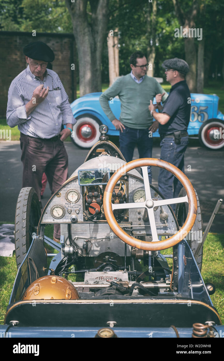 L'homme à la recherche à un 1921 Bugatti Type 13 voiture au Centre du patrimoine mondial de Bicester scramble super événement. Bicester, Oxfordshire, Angleterre. Vintage filtre appliqué Banque D'Images