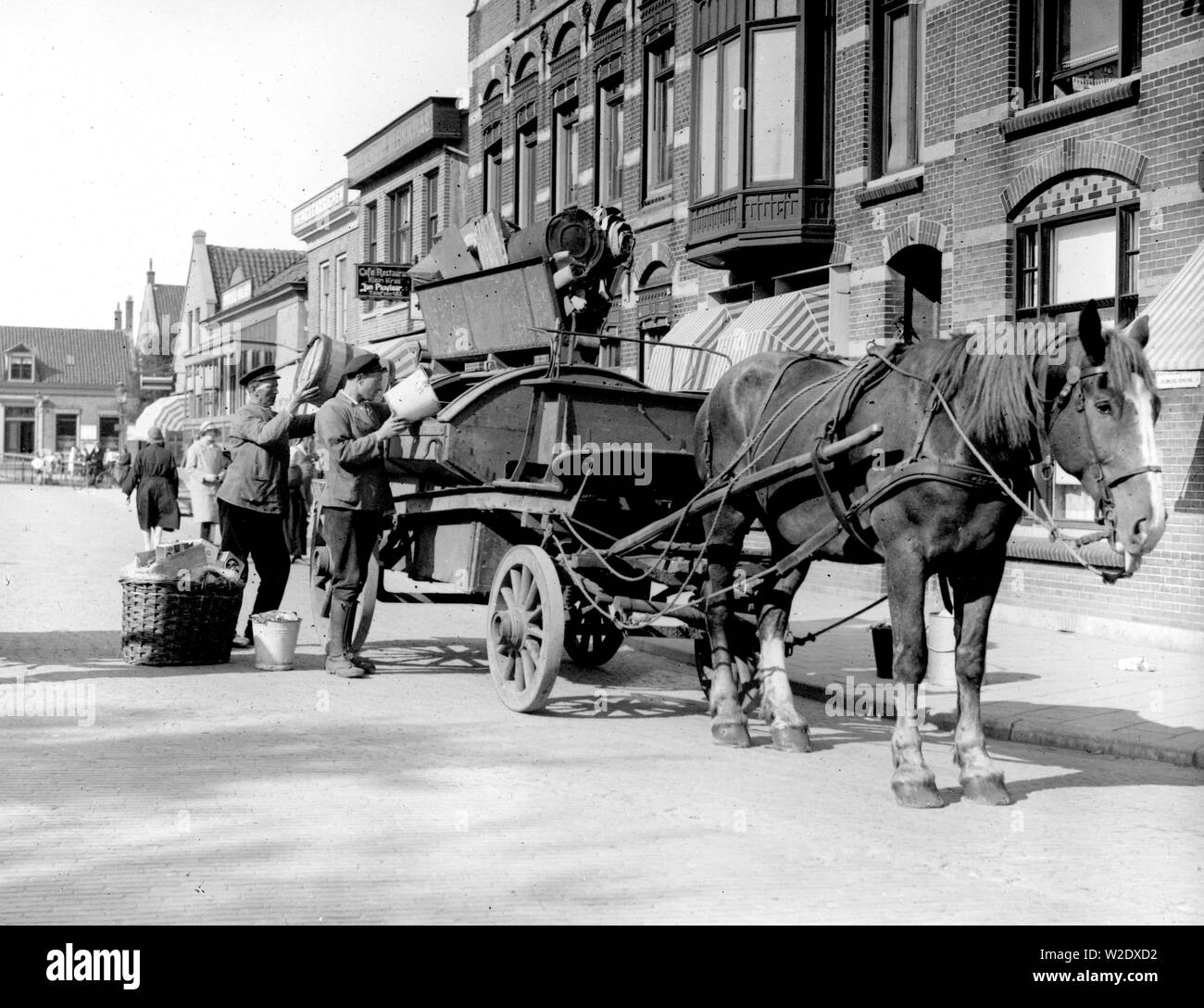 Collecte des déchets ménagers avec cheval et une charrette de la nettoyer. Sur une pancarte 'Cafe Restaurant Klein' ca Puylaar Jan Kras. 1933 Den Helder Pays-Bas Banque D'Images