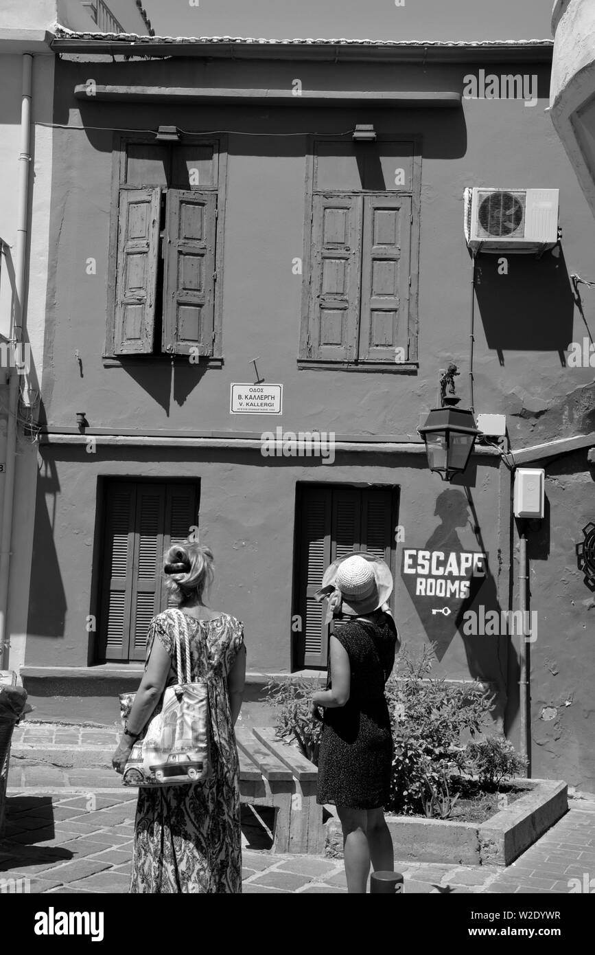 Deux femmes à la recherche de bâtiment restauré utilisé comme une évasion house, old town, Rethymnon, Crète, Grèce. Banque D'Images