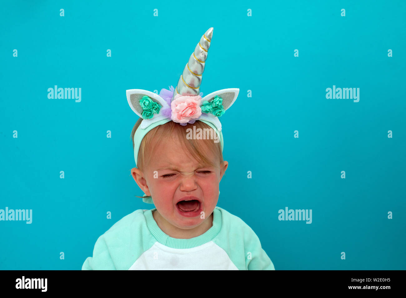 Bébé qui pleure en costume de licorne Banque D'Images
