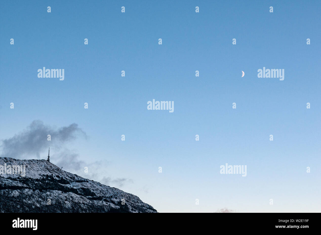 Le mont Ulriken en hiver avec un croissant de lune. Bergen, Norvège Banque D'Images