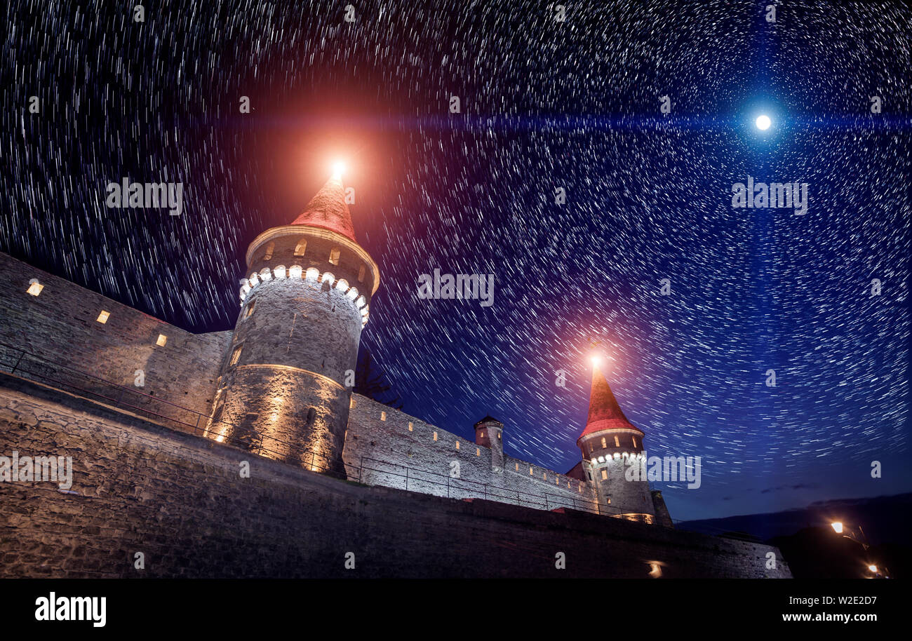 Vue sur le château de Kamianets Podilskyi dans nuit avec ciel étoilé et la lune. L'Ukraine Banque D'Images