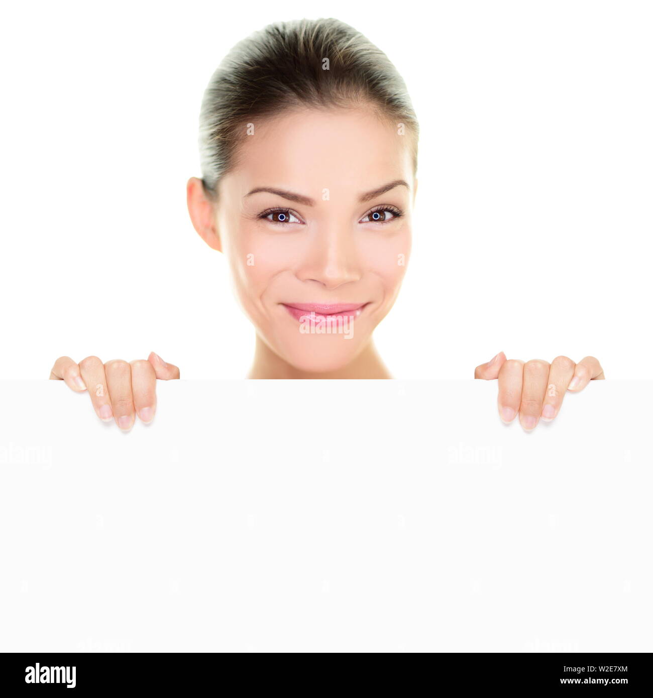 Chinois asiatique femme beauté montrant holding banner sign peeking ci-dessus s'appuyant sur billboard blanc tableau blanc vide en tenant la carte avec les mains. Heureux sain visage frais fille isolée sur fond blanc Banque D'Images