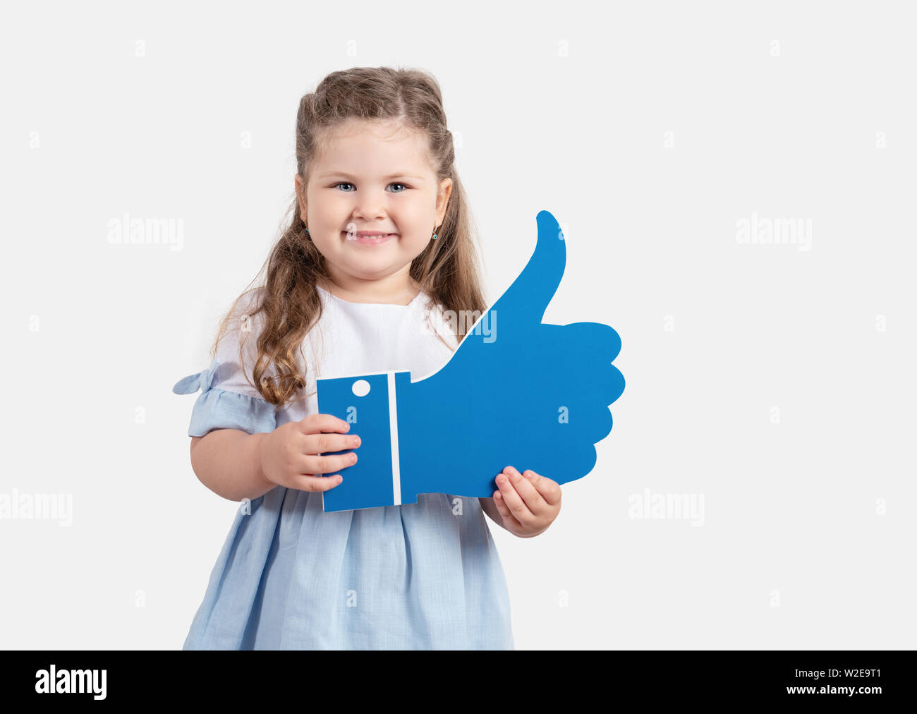 Cute little girl holding cartoon comme sur fond gris.Social media concept Banque D'Images