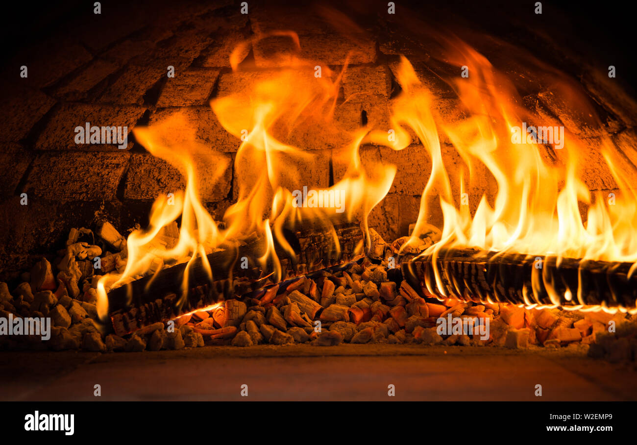 Les flammes d'un four à bois avec des braises et la combustion du bois Banque D'Images Les flammes d'un four à bois avec des braises et la combustion du bois Banque D'Images