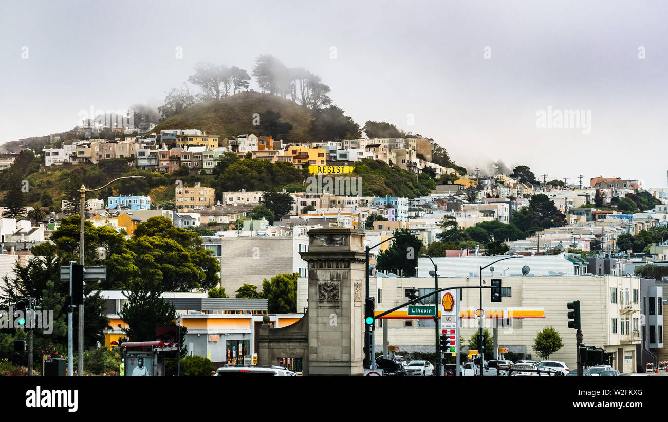 4 juillet 2019 San Francisco / CA / USA - paysage urbain dans le district de coucher du soleil sur un ciel nuageux et jour brumeux ; rangées de maisons construites proches et Gran Banque D'Images