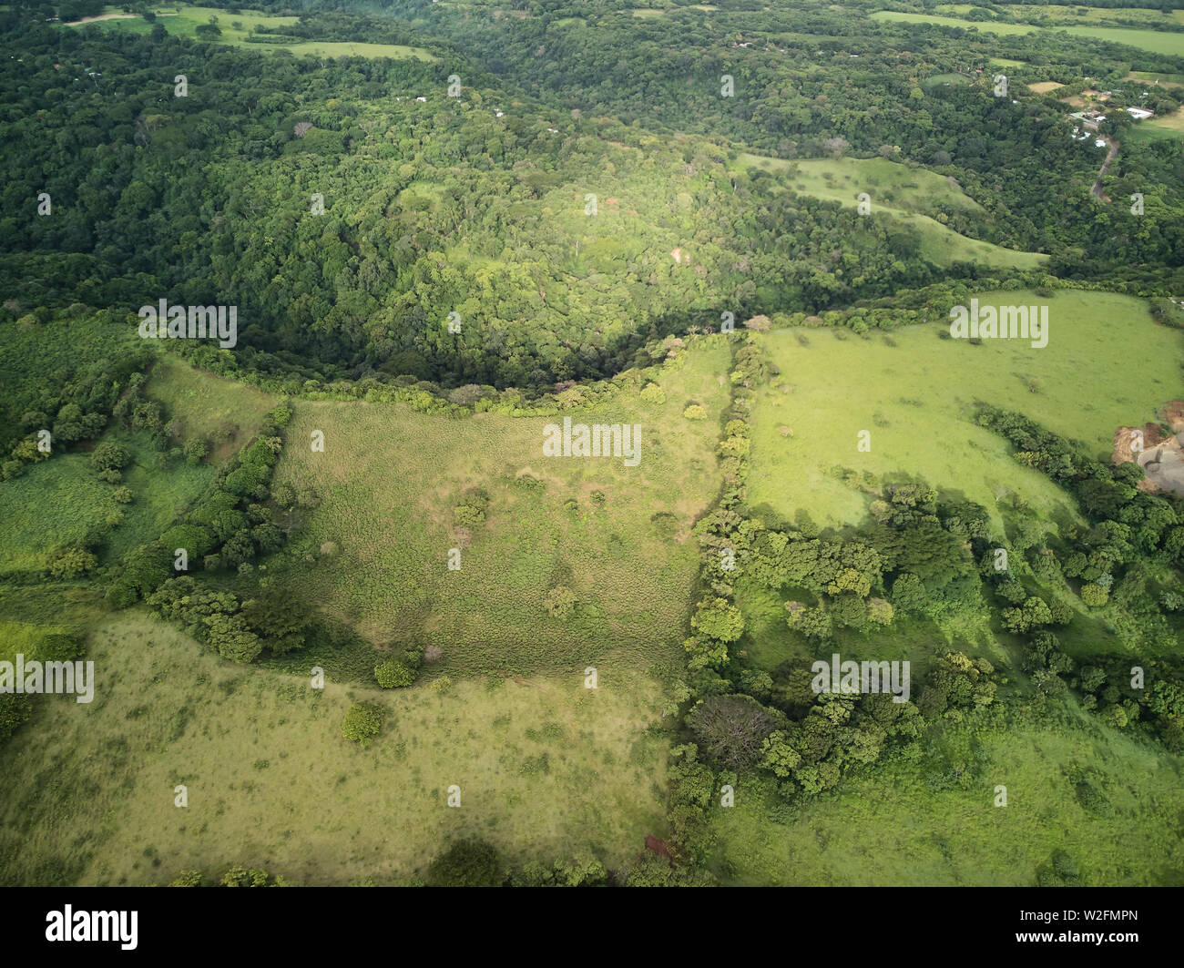 Paysage de collines vertes au-dessus du haut vue sur coucher de soleil drone Banque D'Images