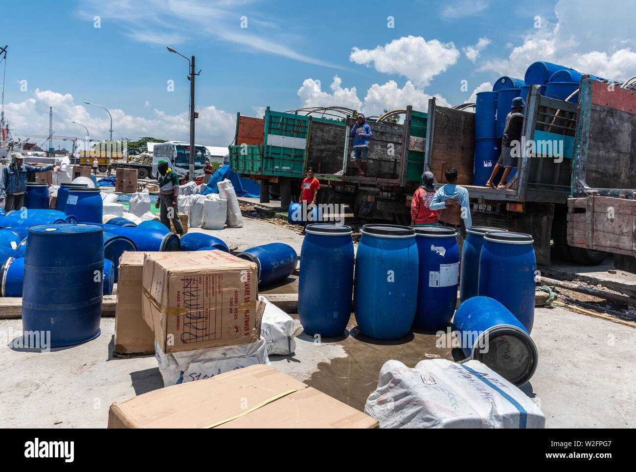 Makassar, Sulawesi, Indonésie - 28 Février 2019 : Paotere Vieux Port. Décharger les hommes bleu large barils d'ouvert retour trucks sous ciel bleu. Barils sur tr Banque D'Images