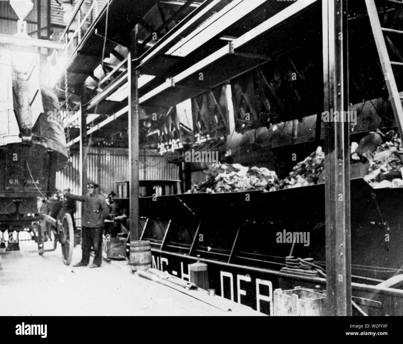 Nettoyage Municipal de tôle ondulée shed intérieur avec un camion à ordures et de déchets en bois voile ca. 1920 Banque D'Images