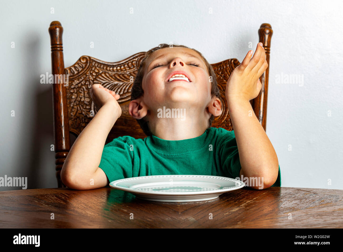 Un jeune garçon assis à une table à la guimauve en un seul près de son visage dans le cadre de l'expérience de guimauve. Banque D'Images