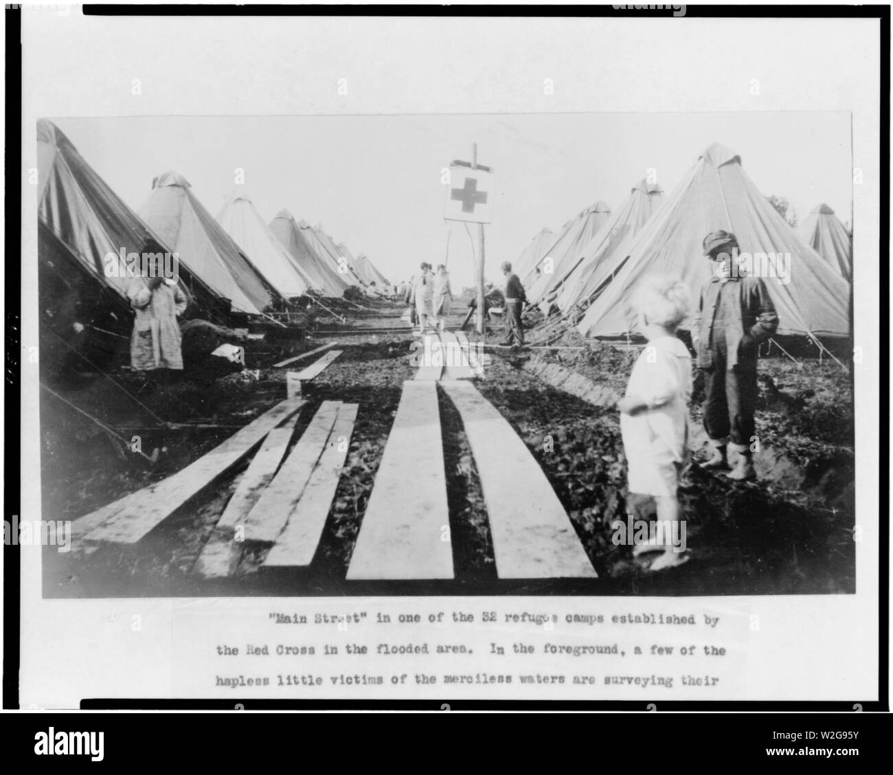 Les enfants le long de la rue 'Main' dans les camp établi par la Croix Rouge pour les victimes des inondations Banque D'Images