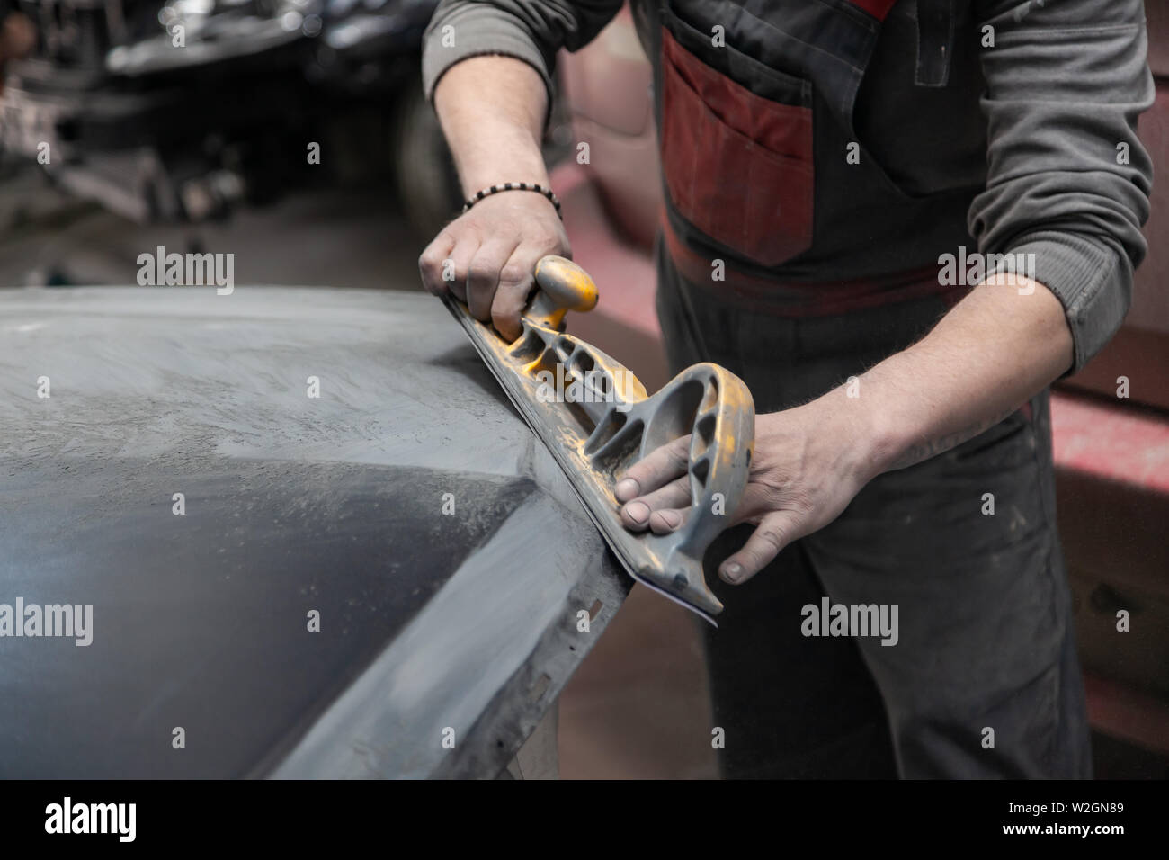 Préparation pour la peinture d'une voiture à l'aide de l'élément capteur d'émeri par un technicien de nivellement avant l'application d'un primaire après l'endommagement d'une partie de la Banque D'Images