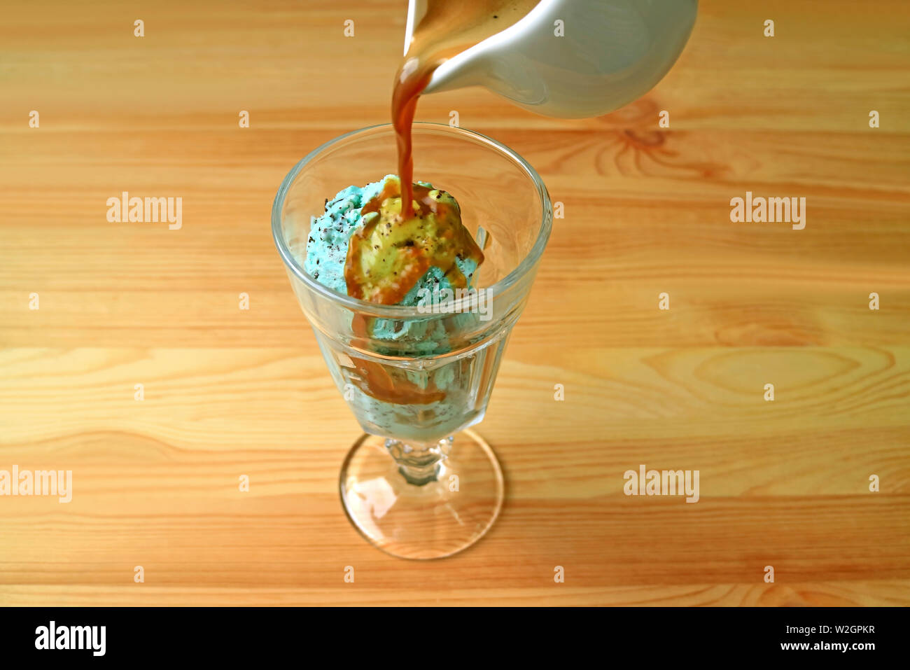 Machine à café expresso est versé sur la menthe crème glacée aux pépites de chocolat pour un Affogato Banque D'Images