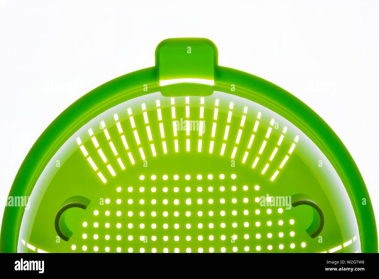 Close-up d'une passoire en plastique vert, un ustensile de cuisine pour égoutter les pâtes, sur un fond blanc. Photo avec copie espace. Banque D'Images