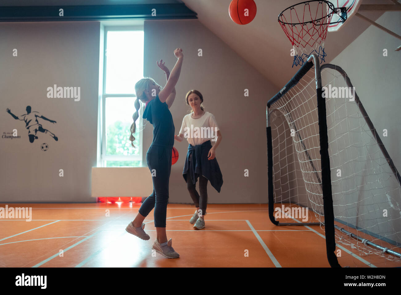 Fille de l'école jouer au basket-ball avec son entraîneur. Banque D'Images