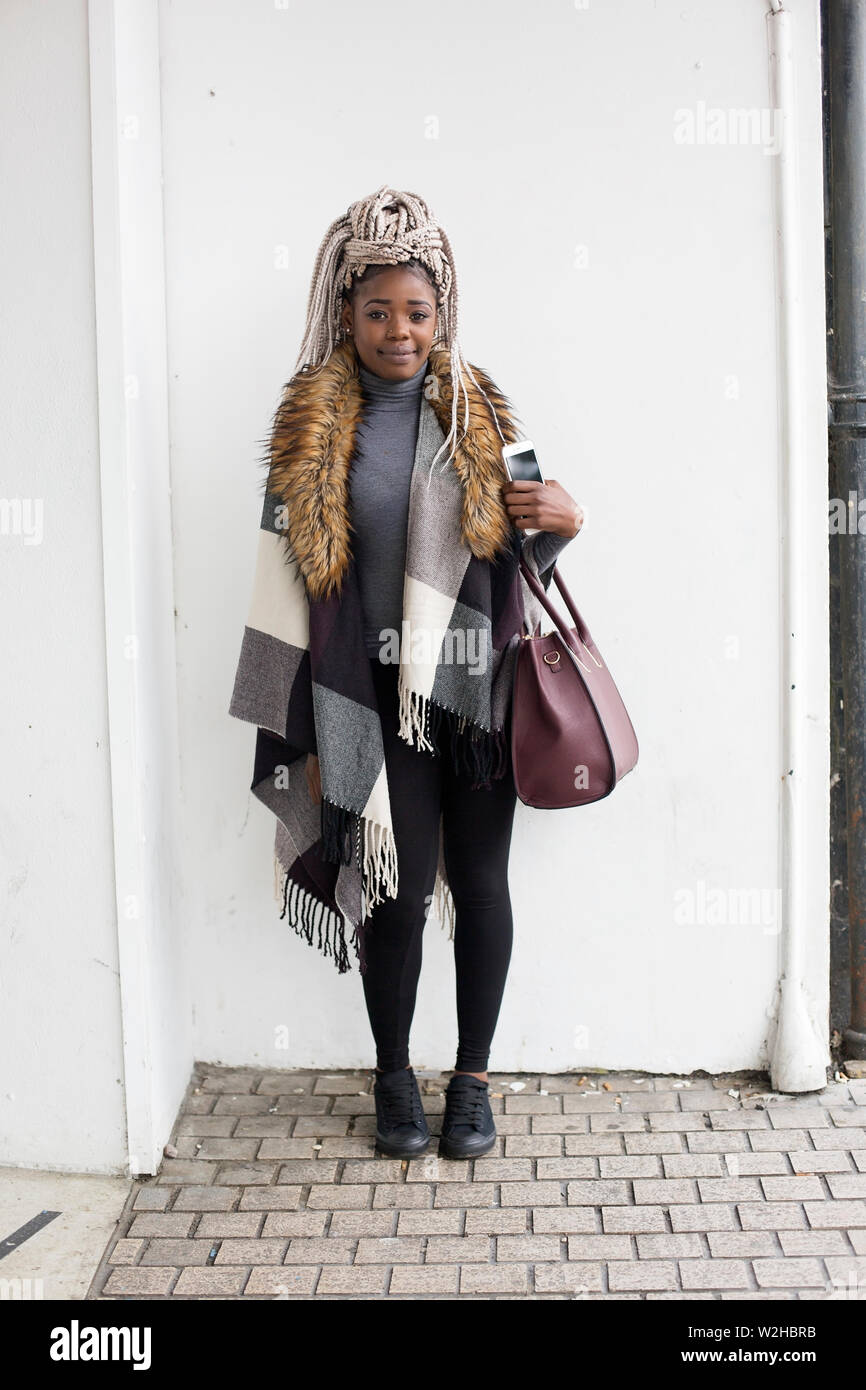 African woman standing à l'angle de la place, Bornemouth, Royaume-Uni, posant avec un hiver confortable fashion style décontracté Banque D'Images