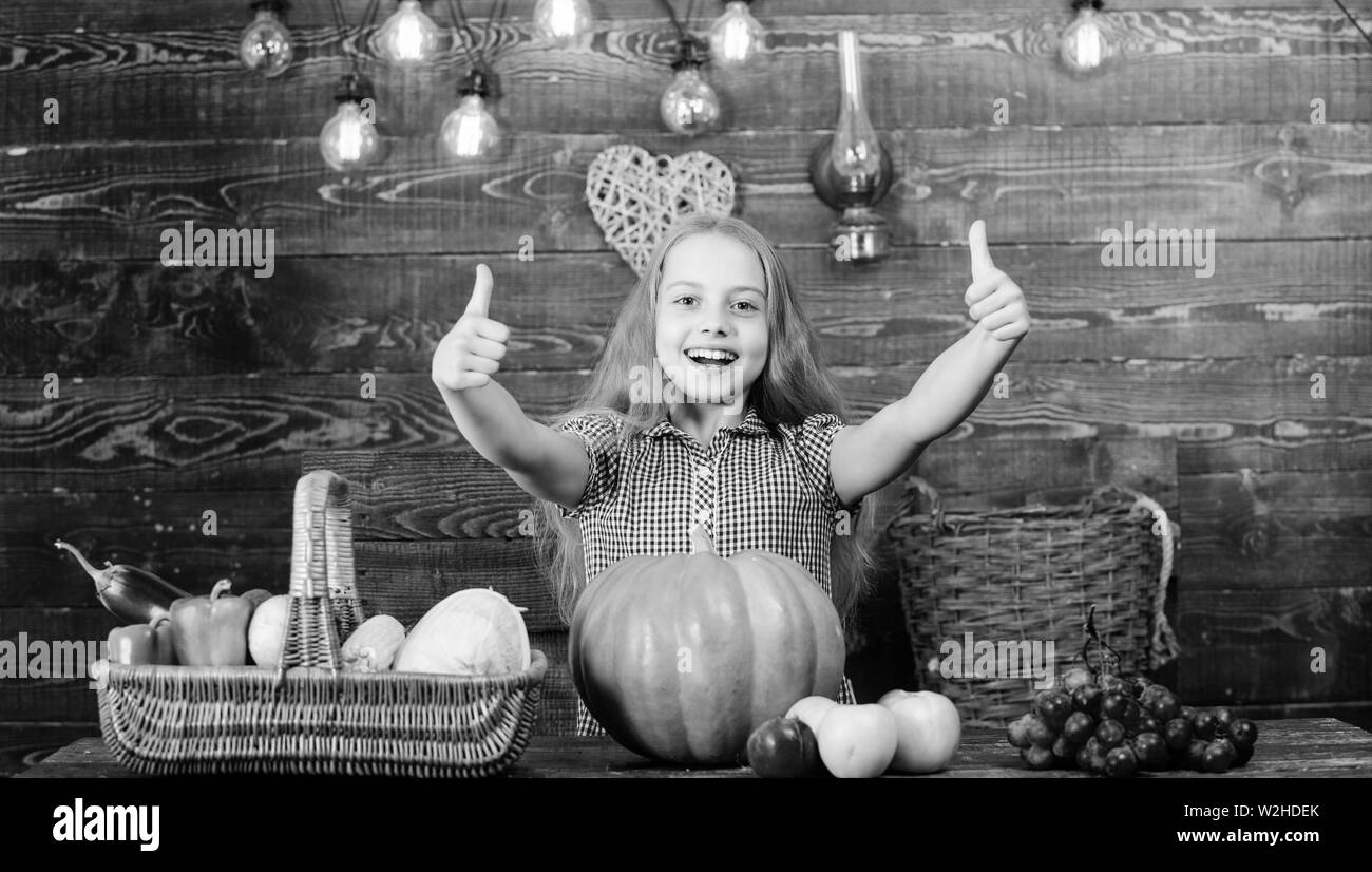 Cultiver votre propre nourriture biologique. Kid agriculteur récolte avec fond de bois. Harvest Festival concept. La petite fille profiter de la vie à la ferme. Le jardinage biologique. Girl kid au marché à la ferme avec des légumes bio. Banque D'Images