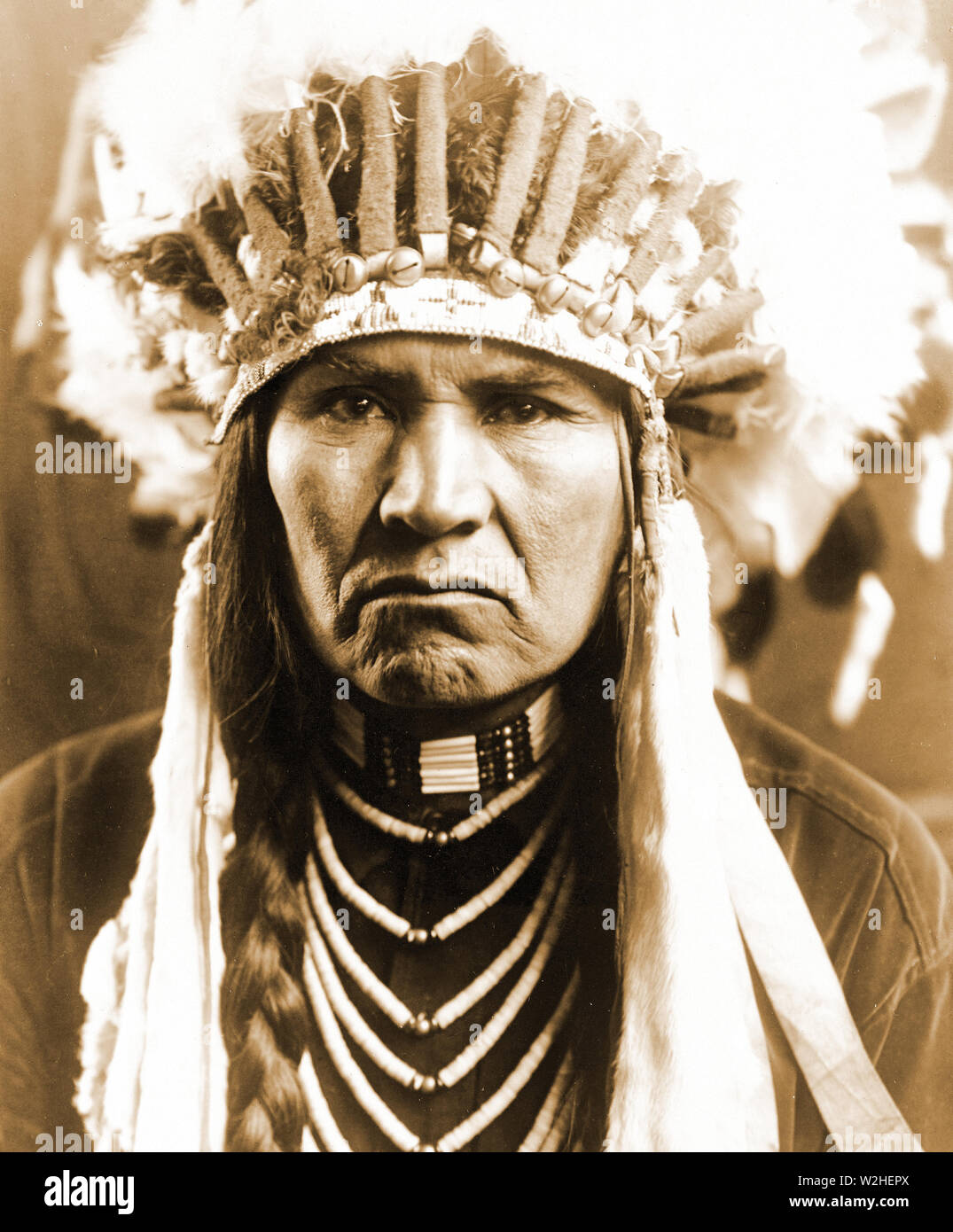 Edward S. Curtis indiens des États-Unis - Nez Percé l'homme en pleine plume  coiffure, cheveux tressés, colliers et ca. 1910 Photo Stock - Alamy